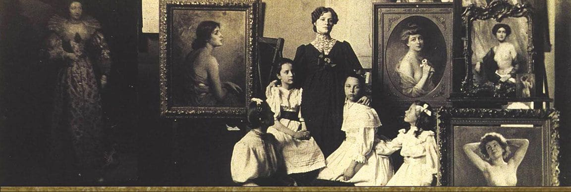 A woman standing with four girls in white dresses among framed portraits in the Stember studio
